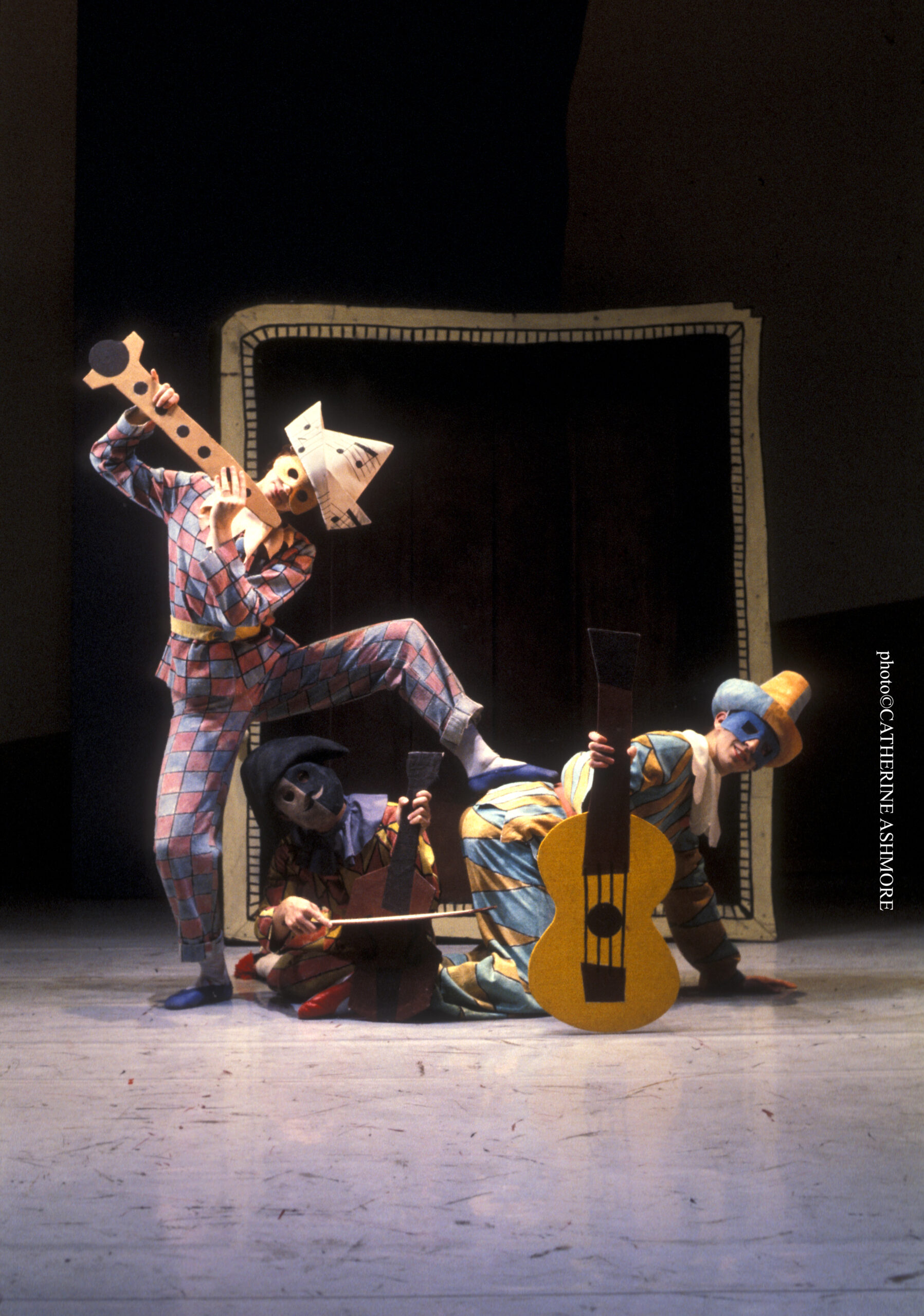 A group of clowns playing a guitar on a stage.