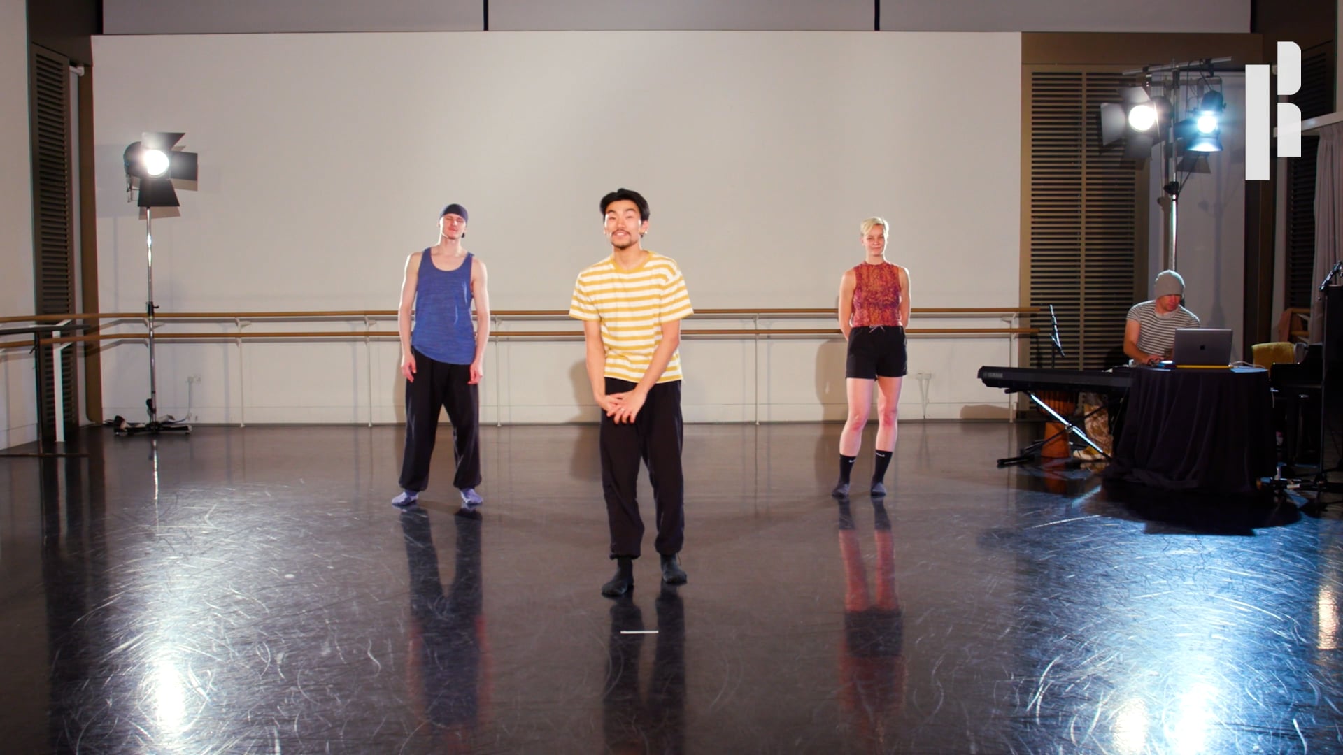 A group of people standing in a dance studio.