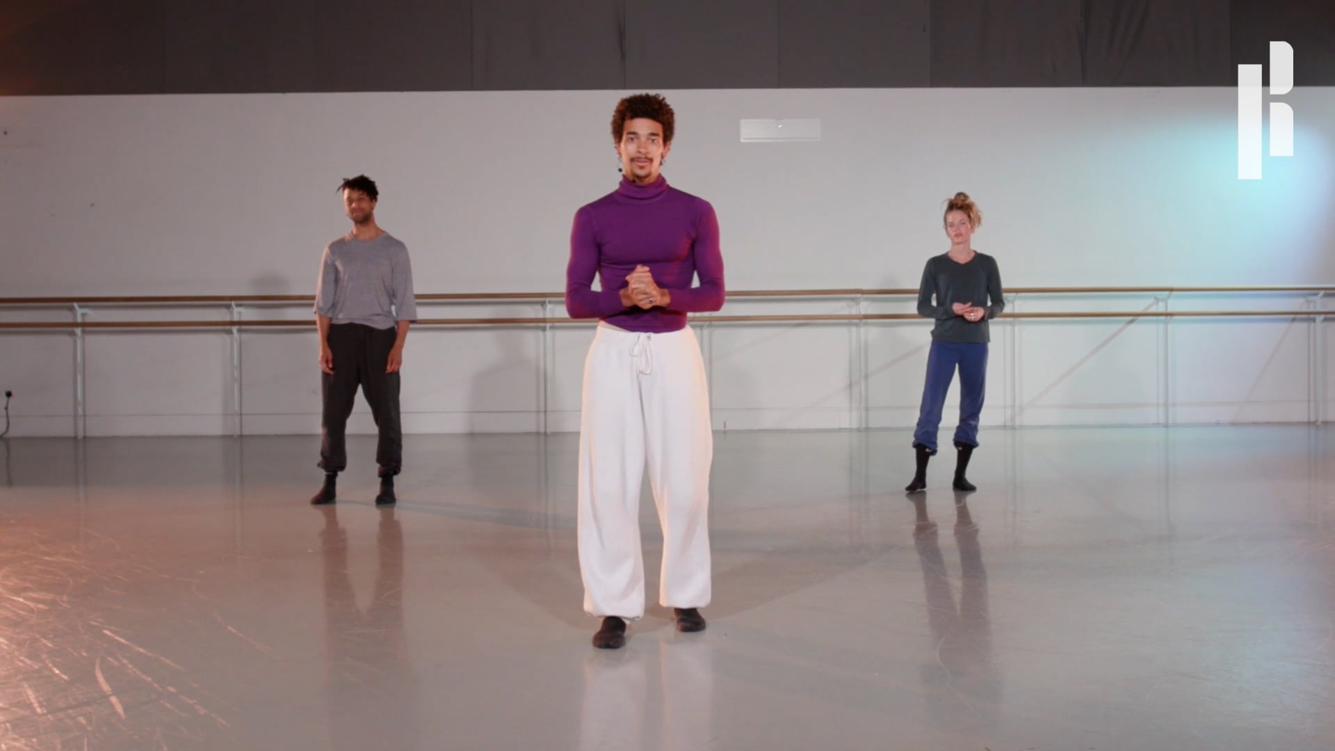 A group of people standing in a dance studio.