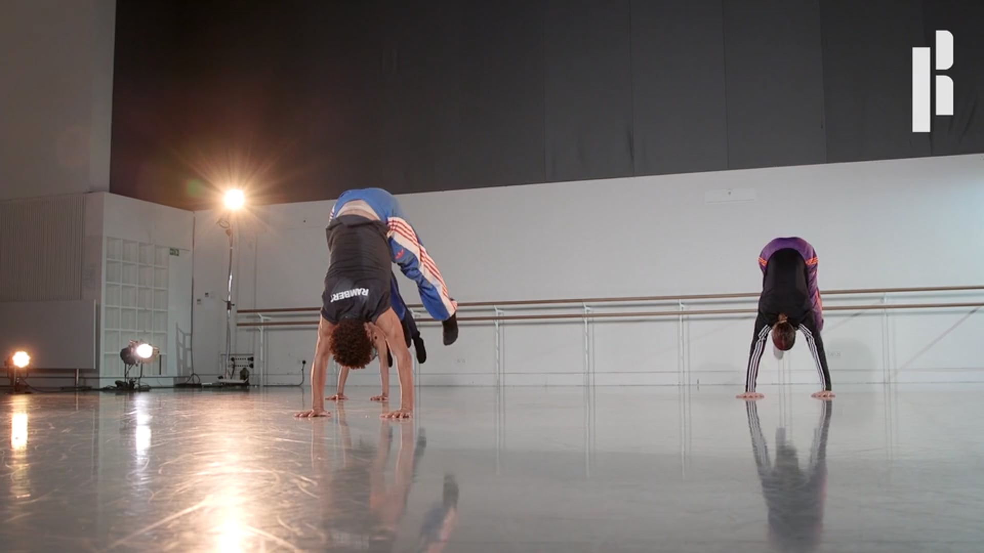 Two dancers doing handstands in a dance studio.