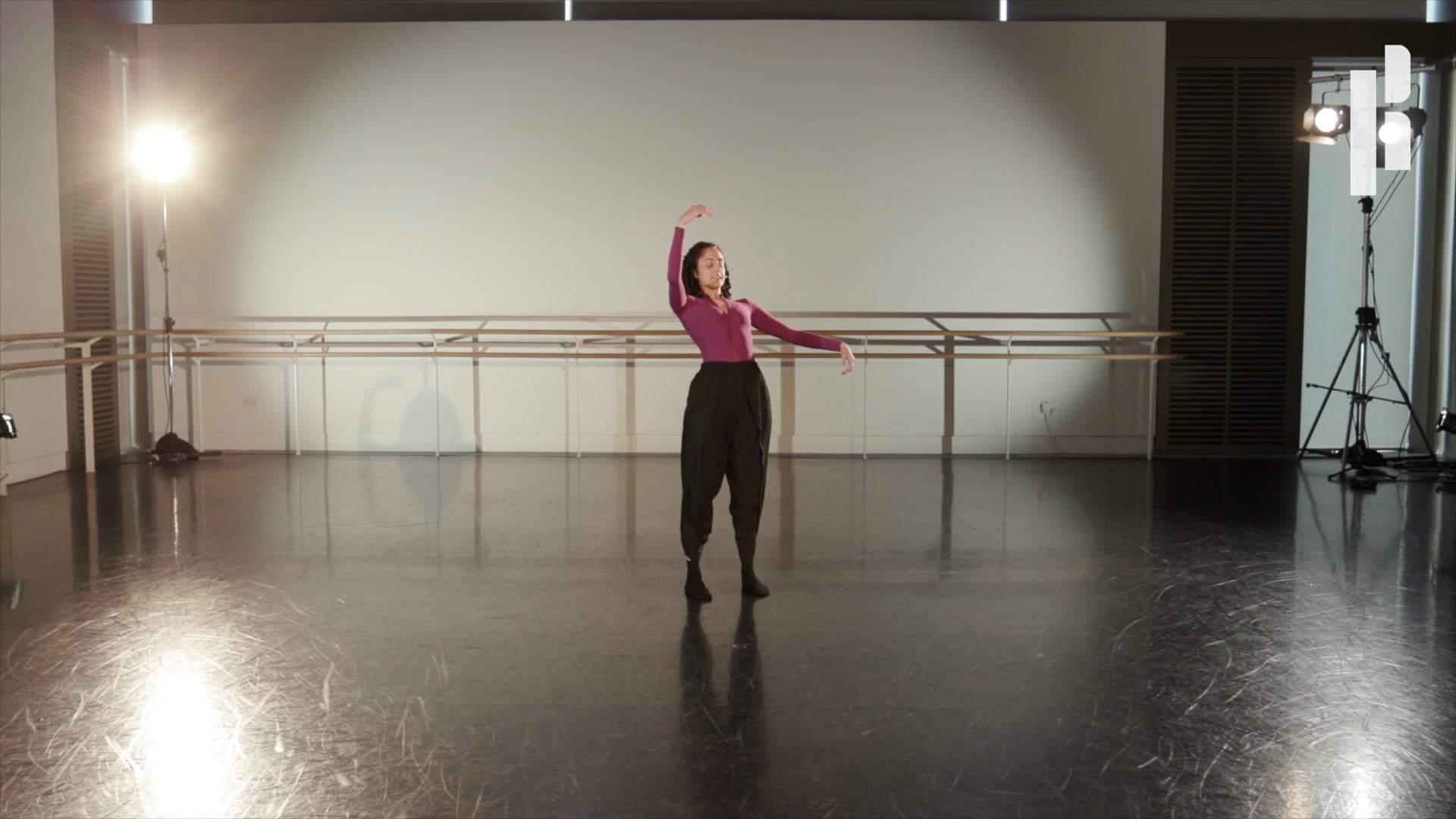 A woman is dancing in an empty dance studio.