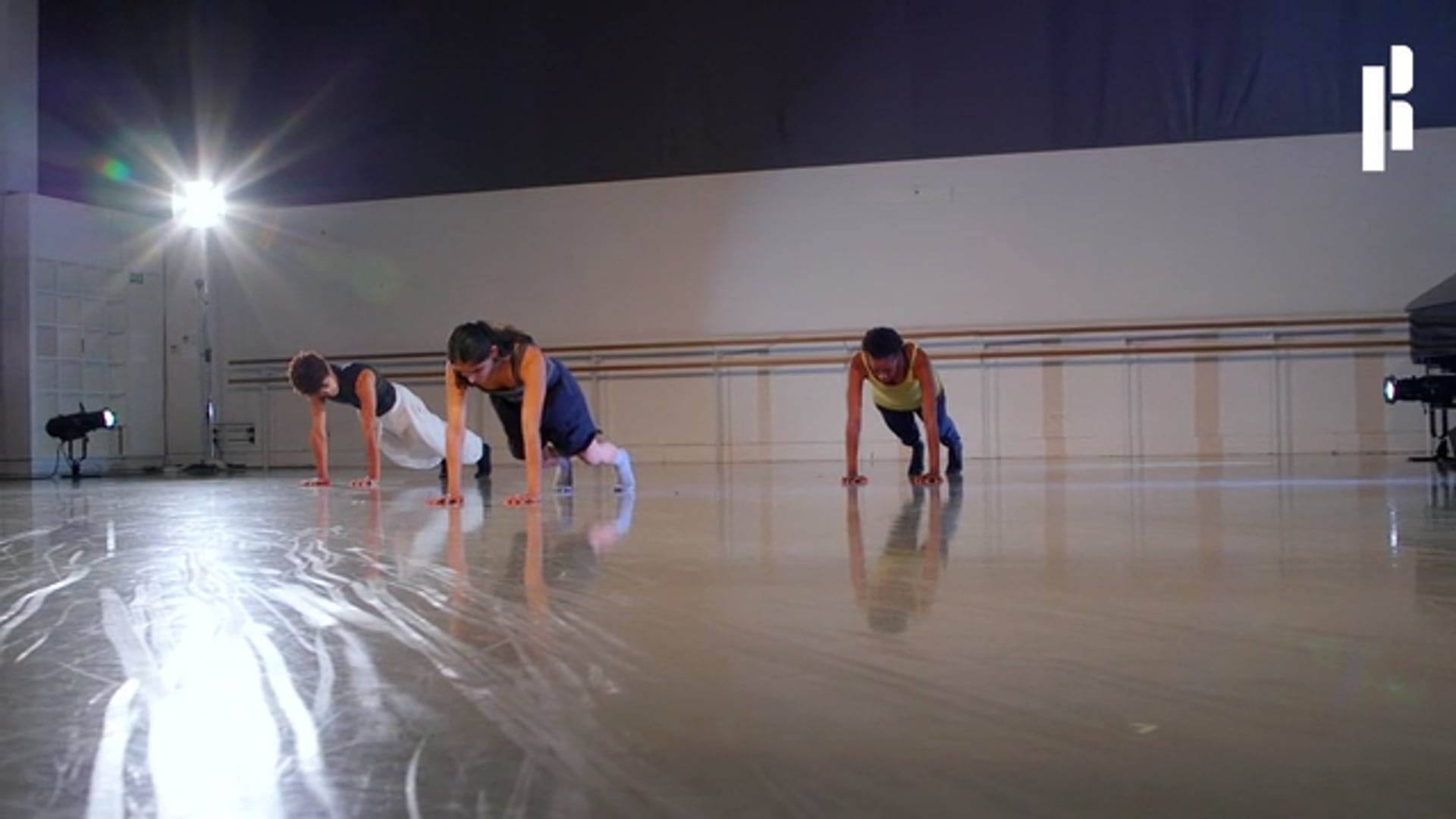 A group of dancers practicing in a dance studio.