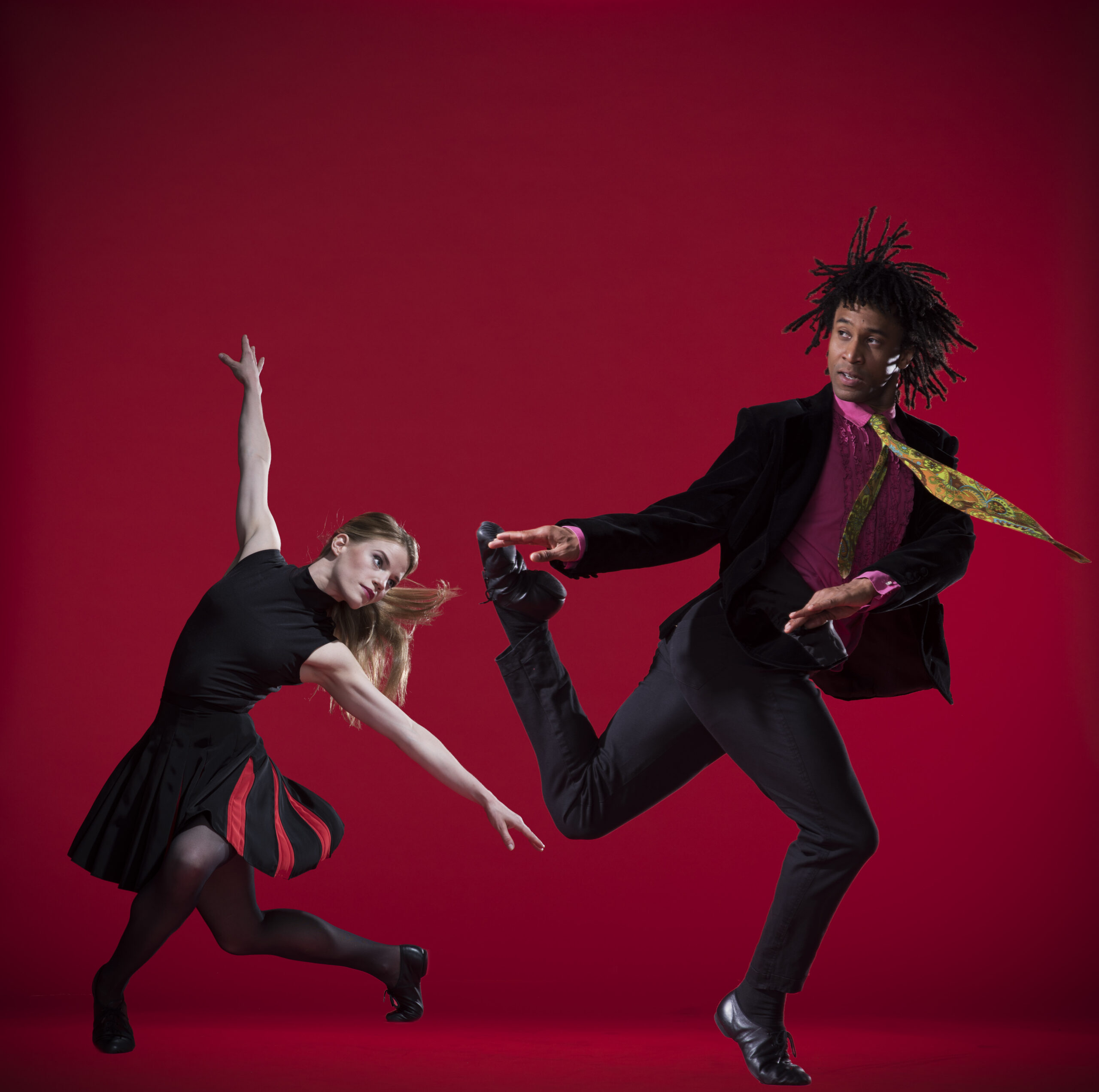 A man and a woman dancing on a red background.