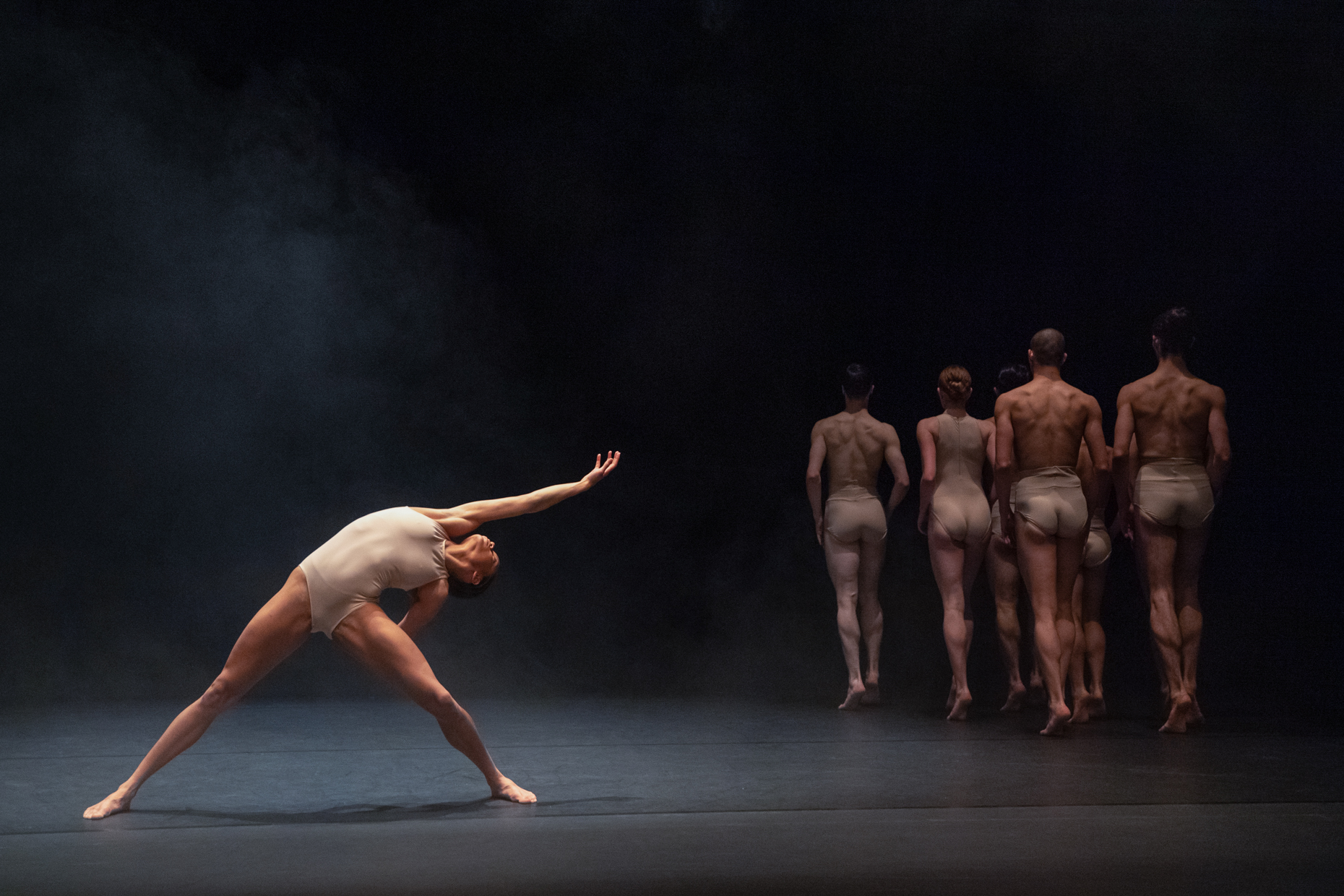 A group of dancers on a stage with smoke in the background.