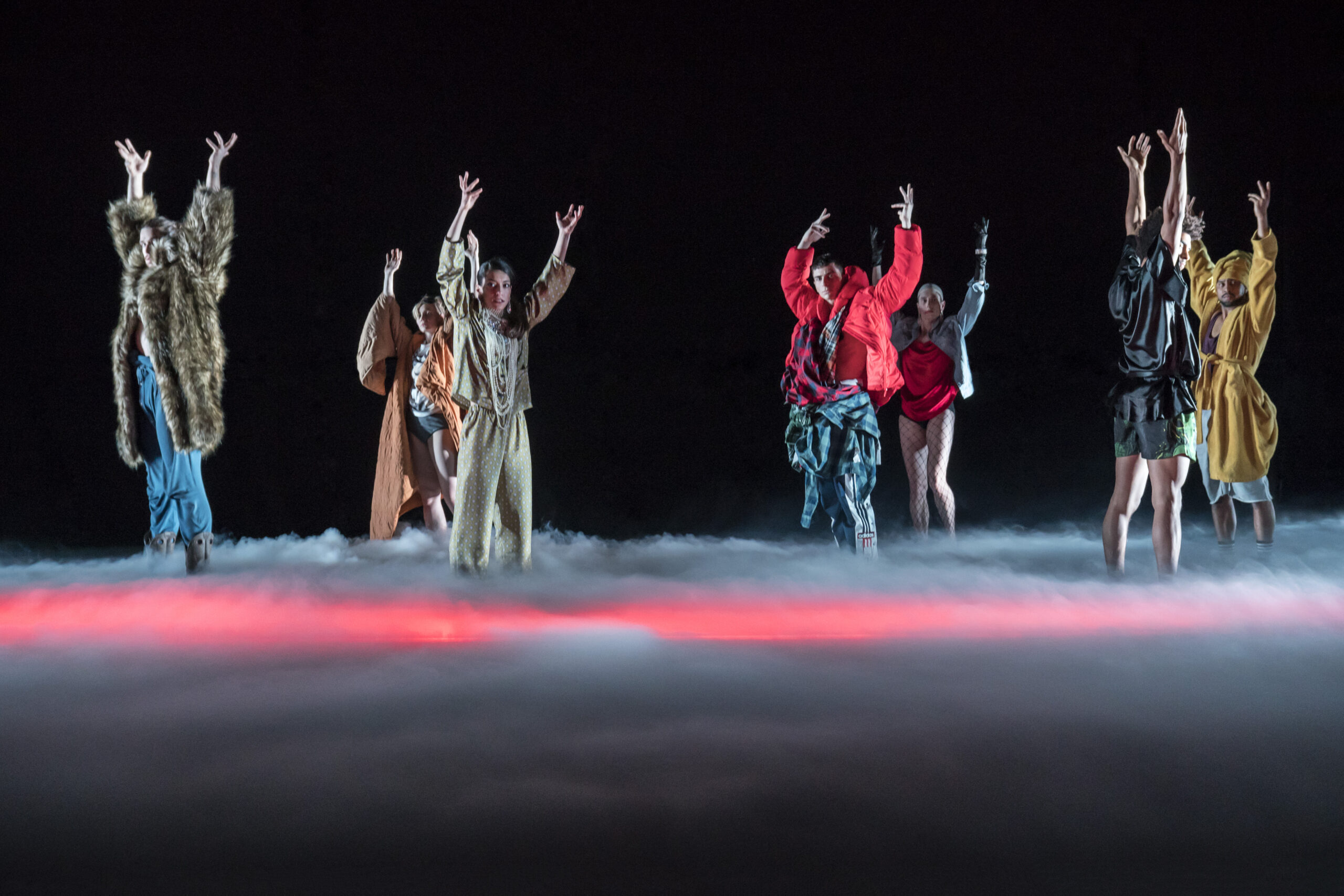 A group of dancers on a stage in the clouds.