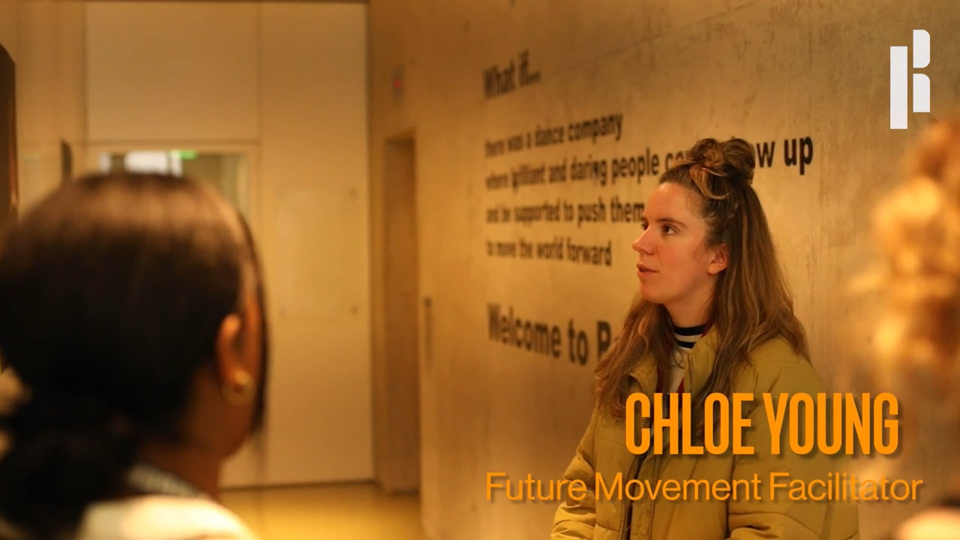 A group of women talking in front of a wall with the words claire young future movement educator.