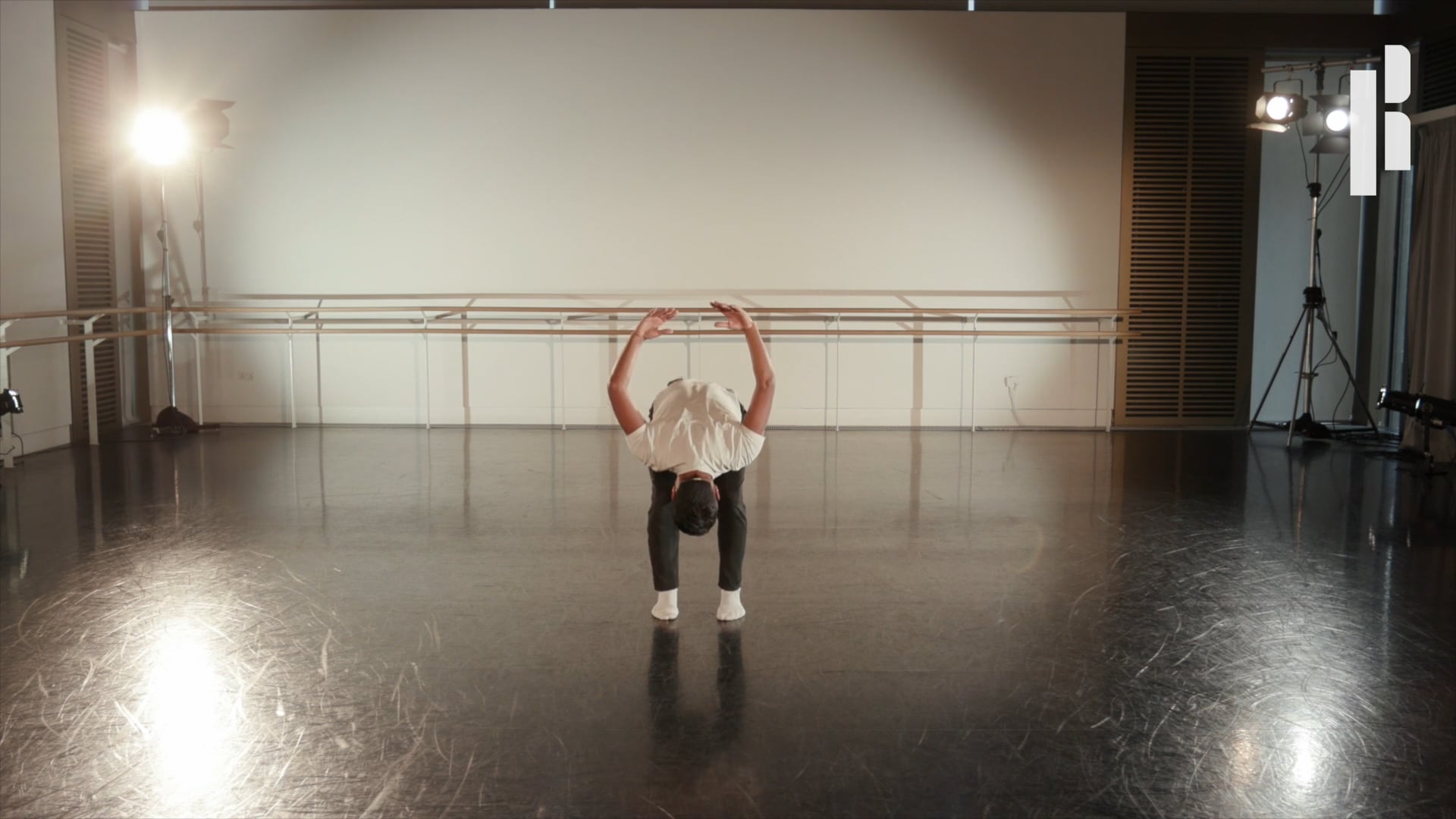 A dancer doing a handstand in a dance studio.