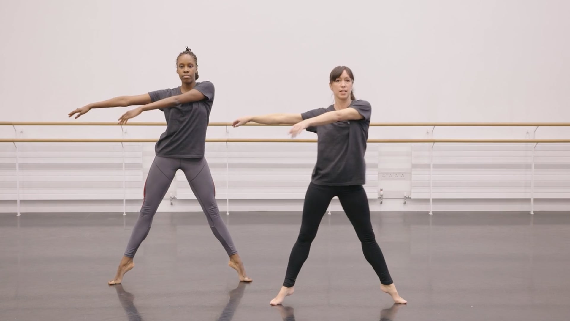 Two dancers practicing in a dance studio.