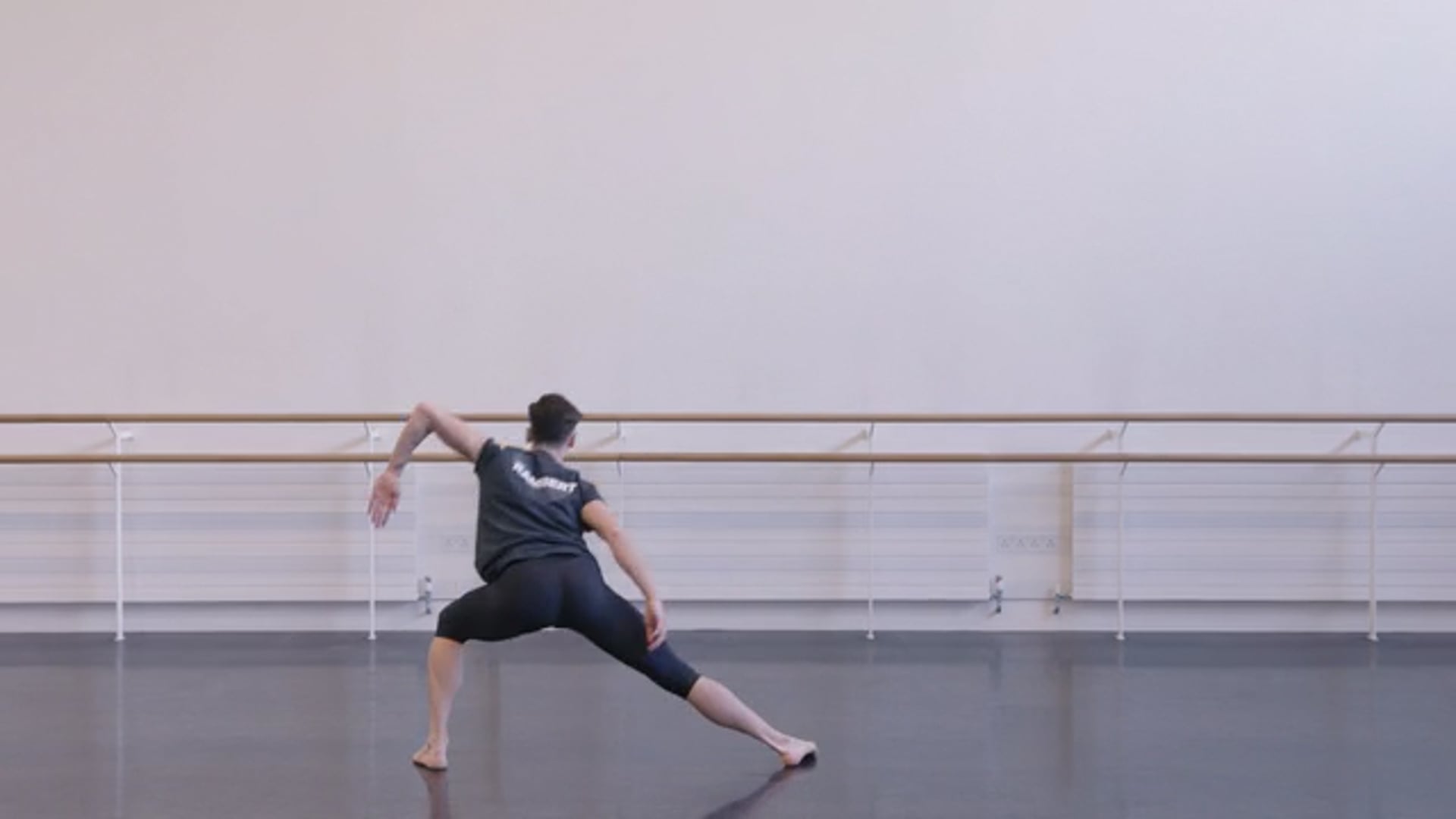 A woman in a black shirt is doing a ballet pose.