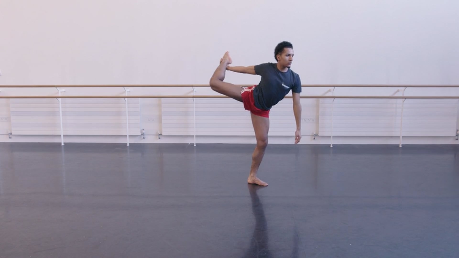 A young dancer doing a splits in a dance studio.