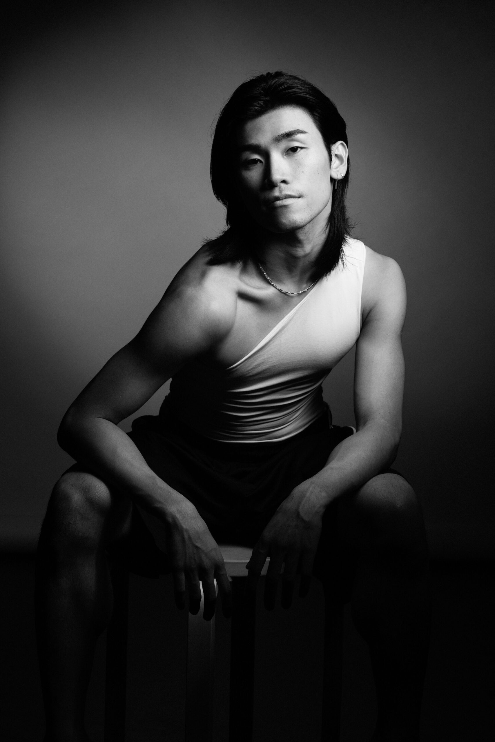 a black and white photo of a man in a tank top.