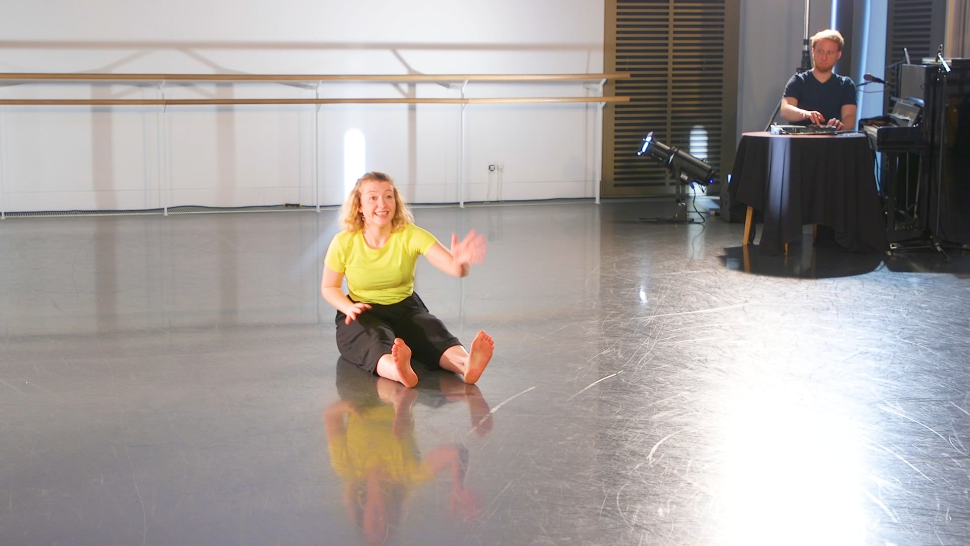 a woman sitting on the floor in a dance studio.