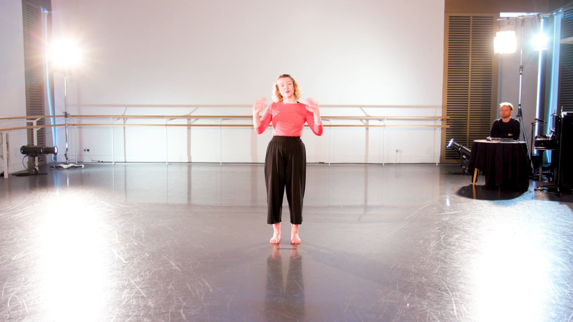 a woman in a pink top is standing on a stage.