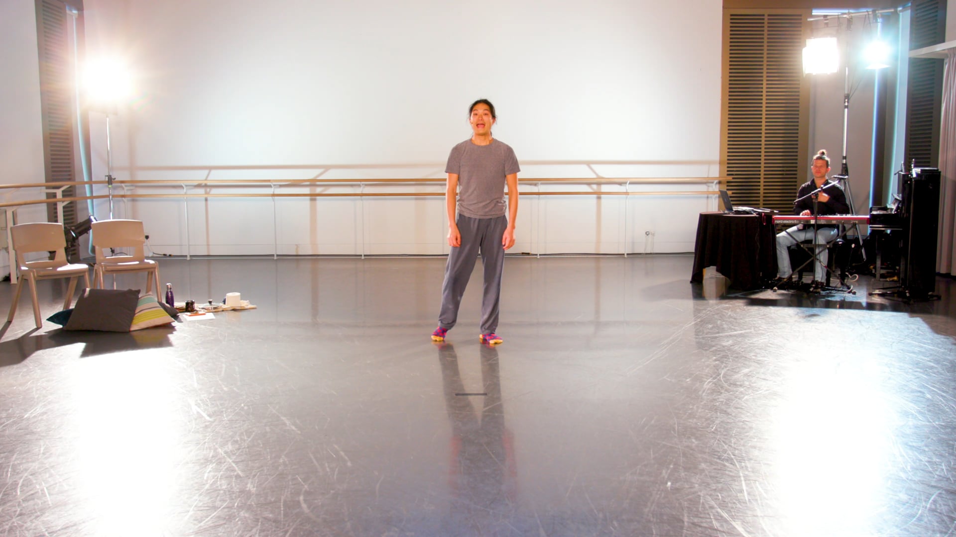 a man standing on a stage in a dance studio.