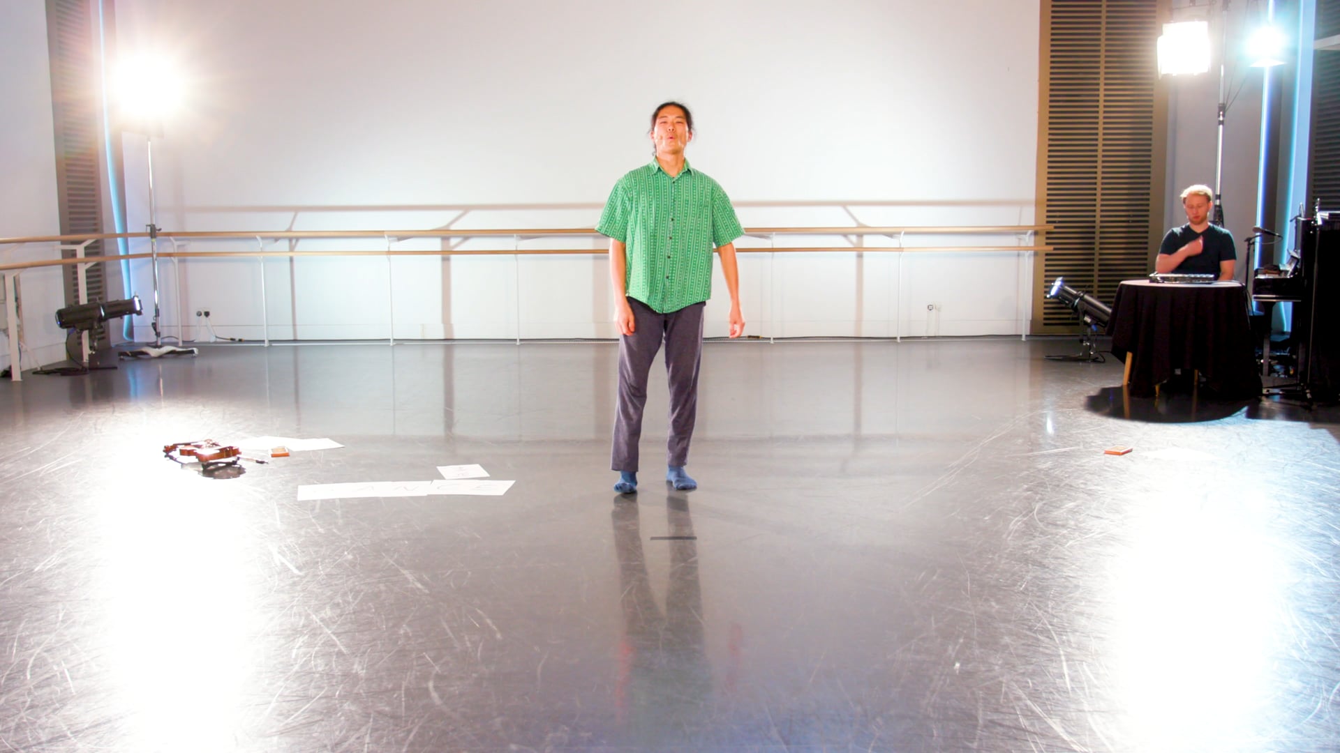 a man standing on a stage in a green shirt.