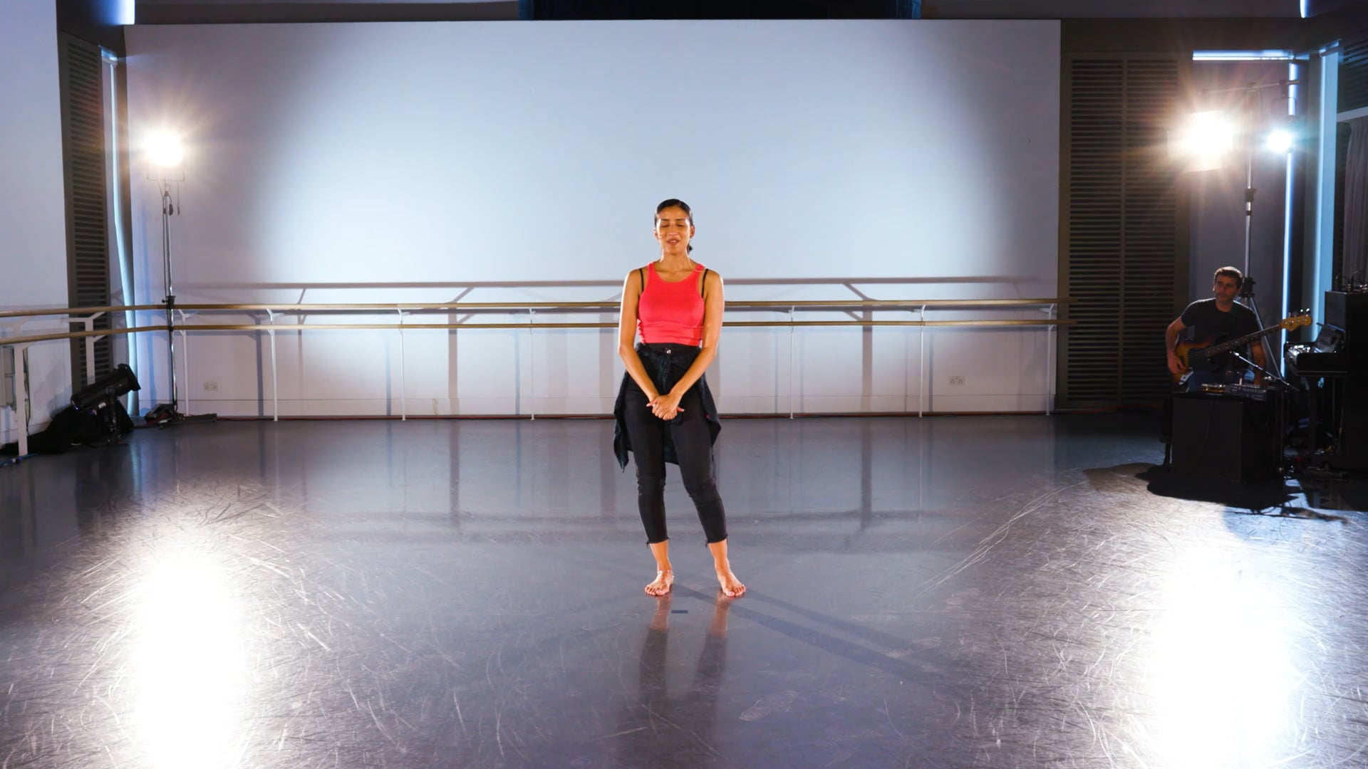 a woman standing on a stage in a dance studio.