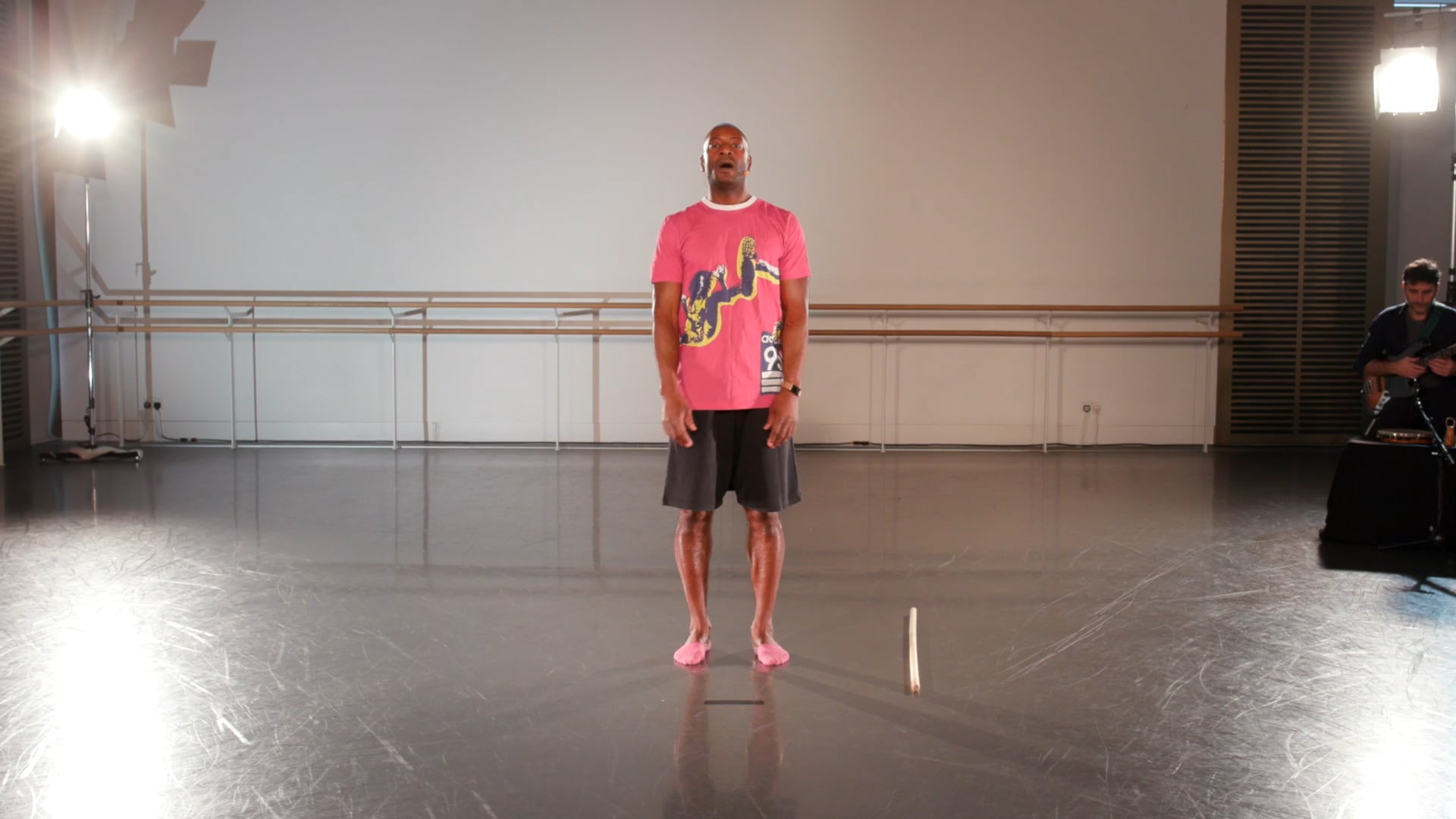 a man in a pink shirt standing in a room.