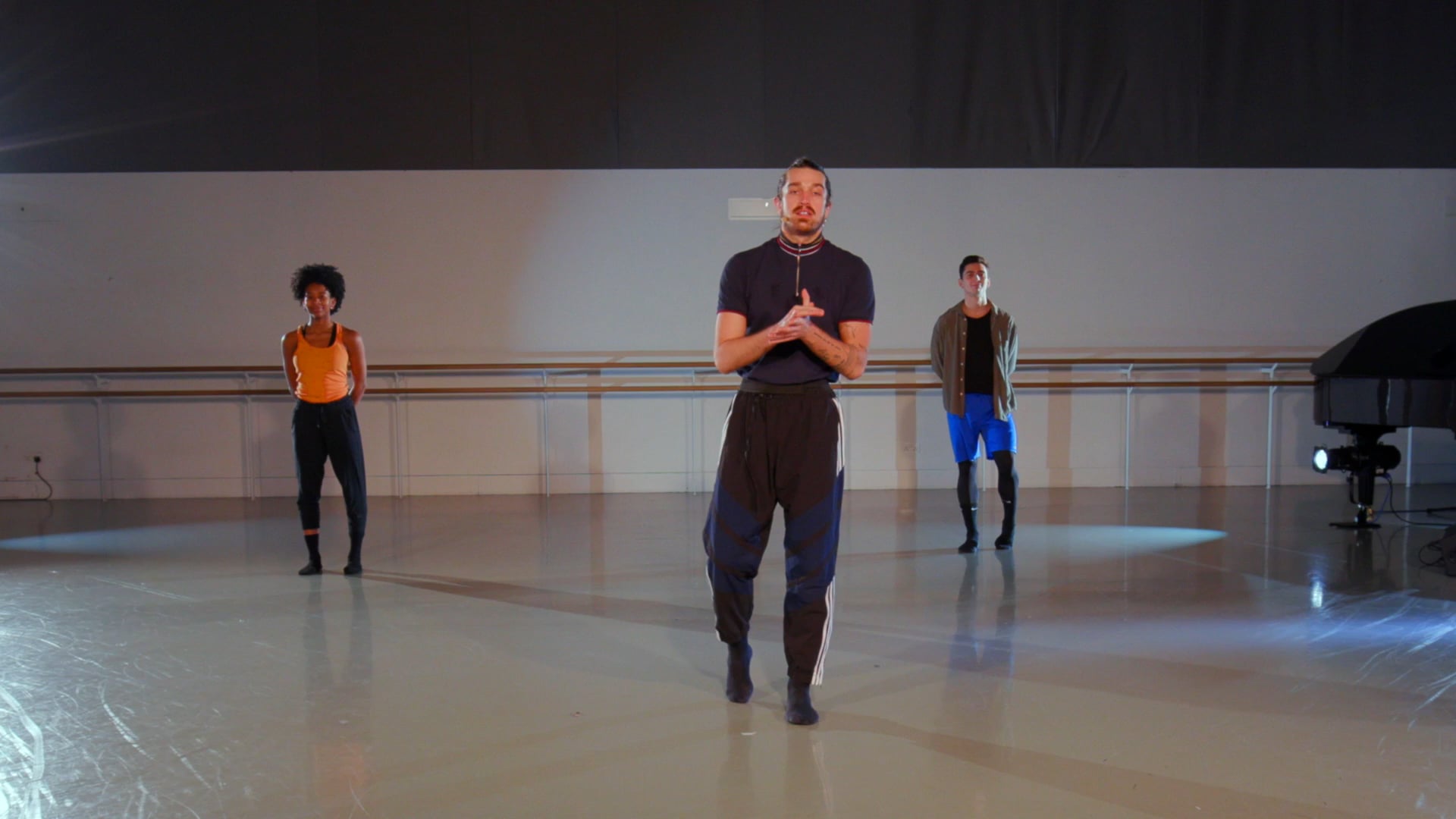a man standing in front of a group of dancers.