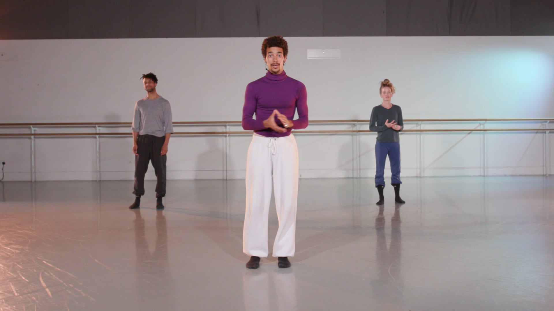 a group of people standing in a dance studio.