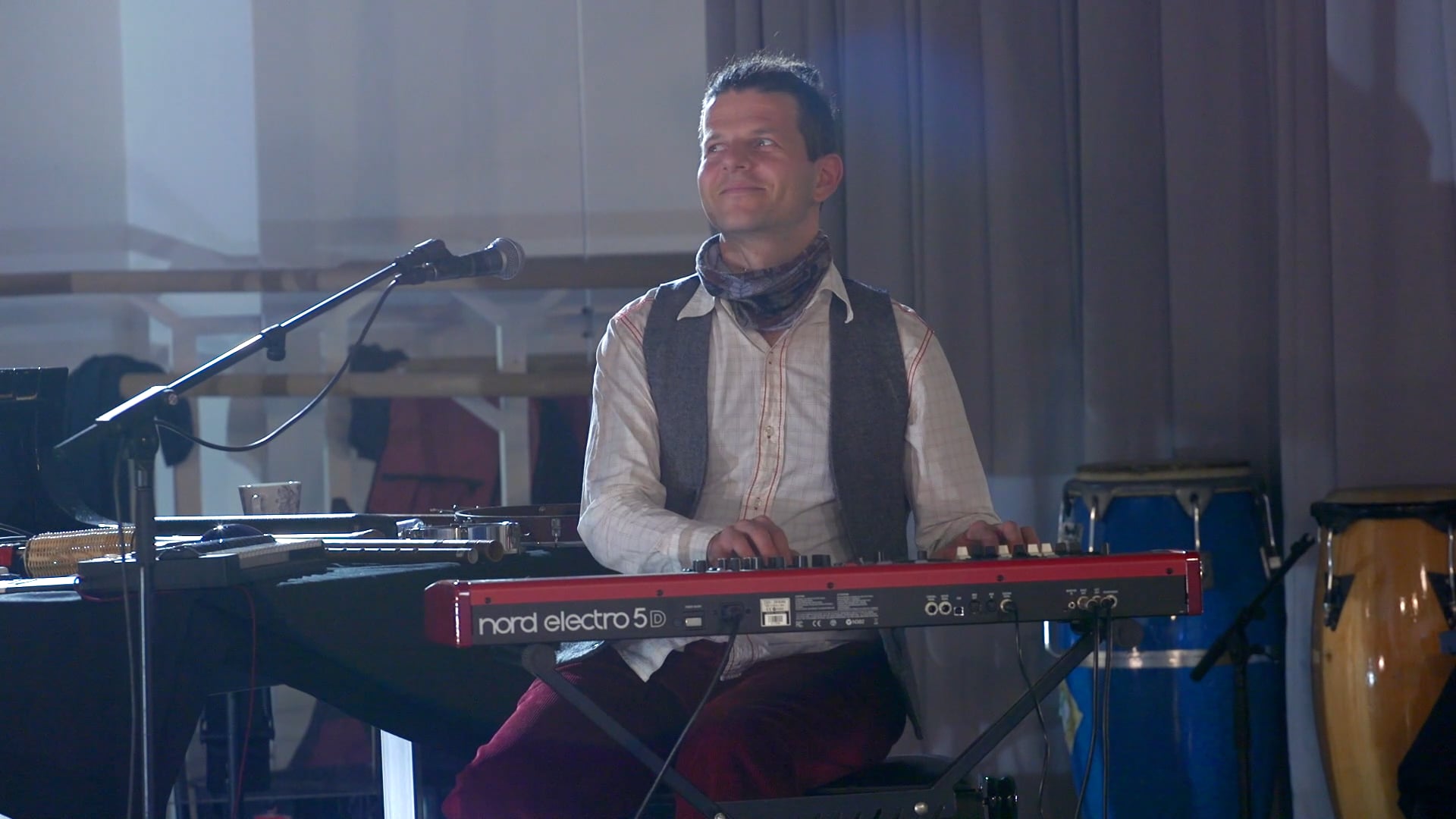 a man playing a keyboard in front of a microphone.