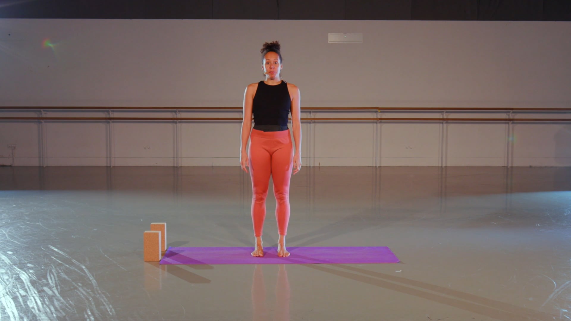a woman is standing on a purple mat.