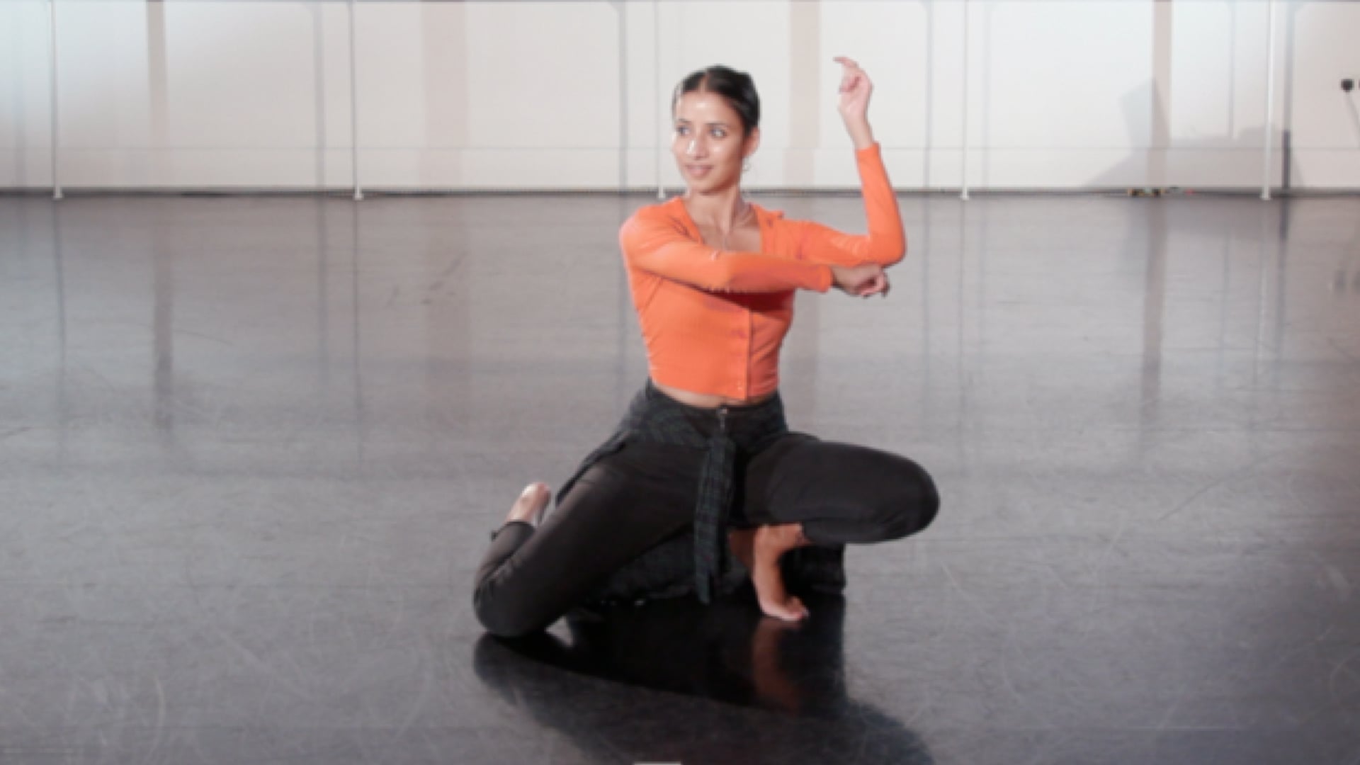 a woman in an orange shirt is doing a yoga pose.