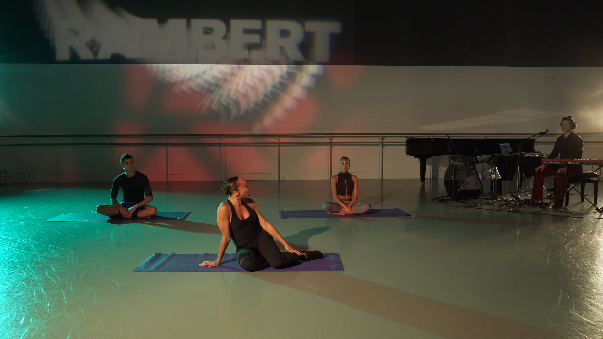 a group of people sitting on yoga mats in a room.