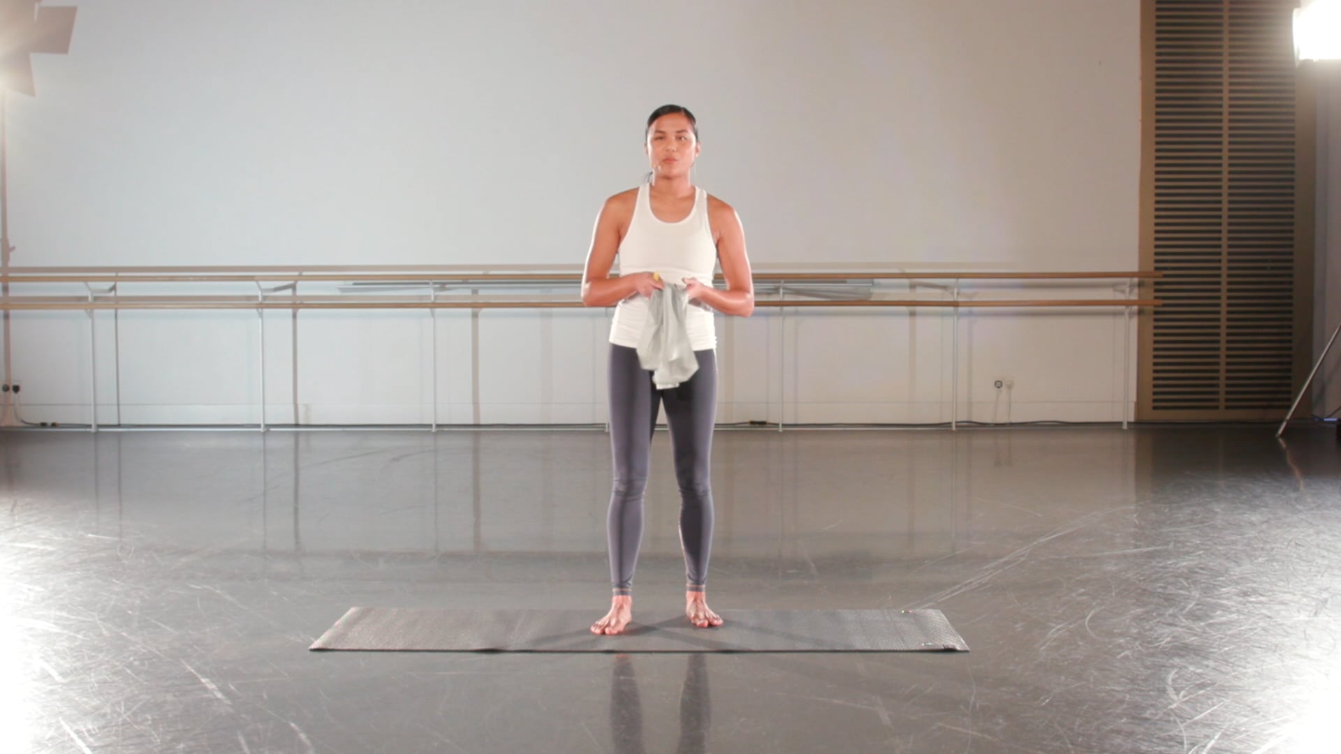 a woman standing on a mat in a dance studio.