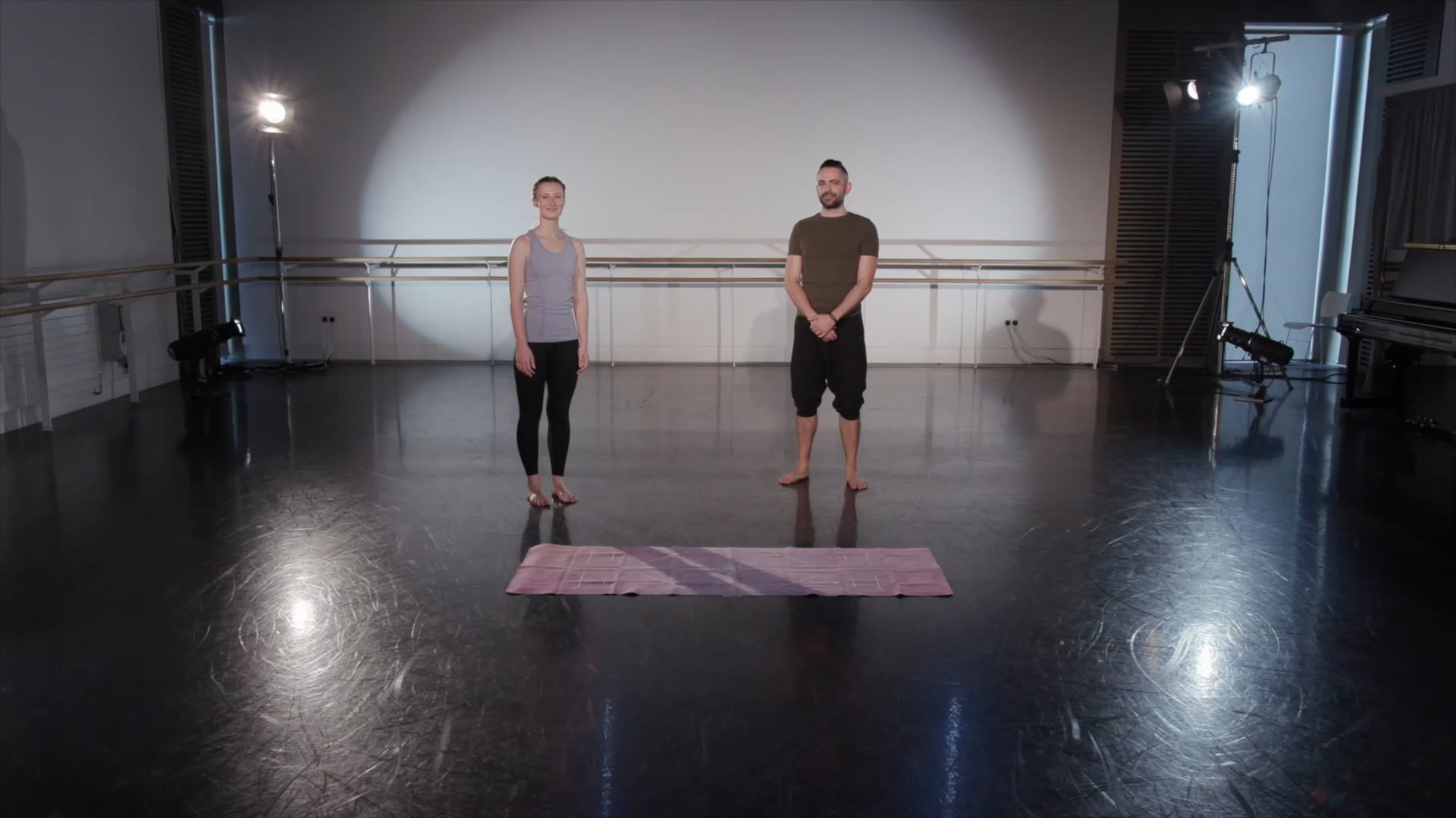 a man and a woman standing in a dance studio.