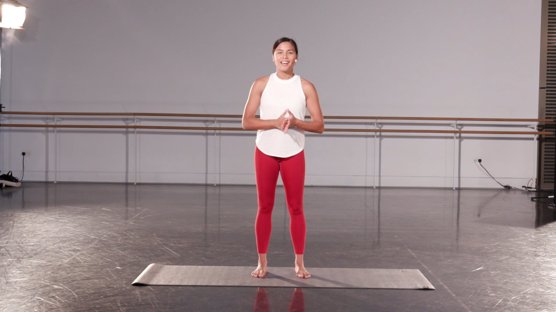 a woman standing on a mat in a dance studio.