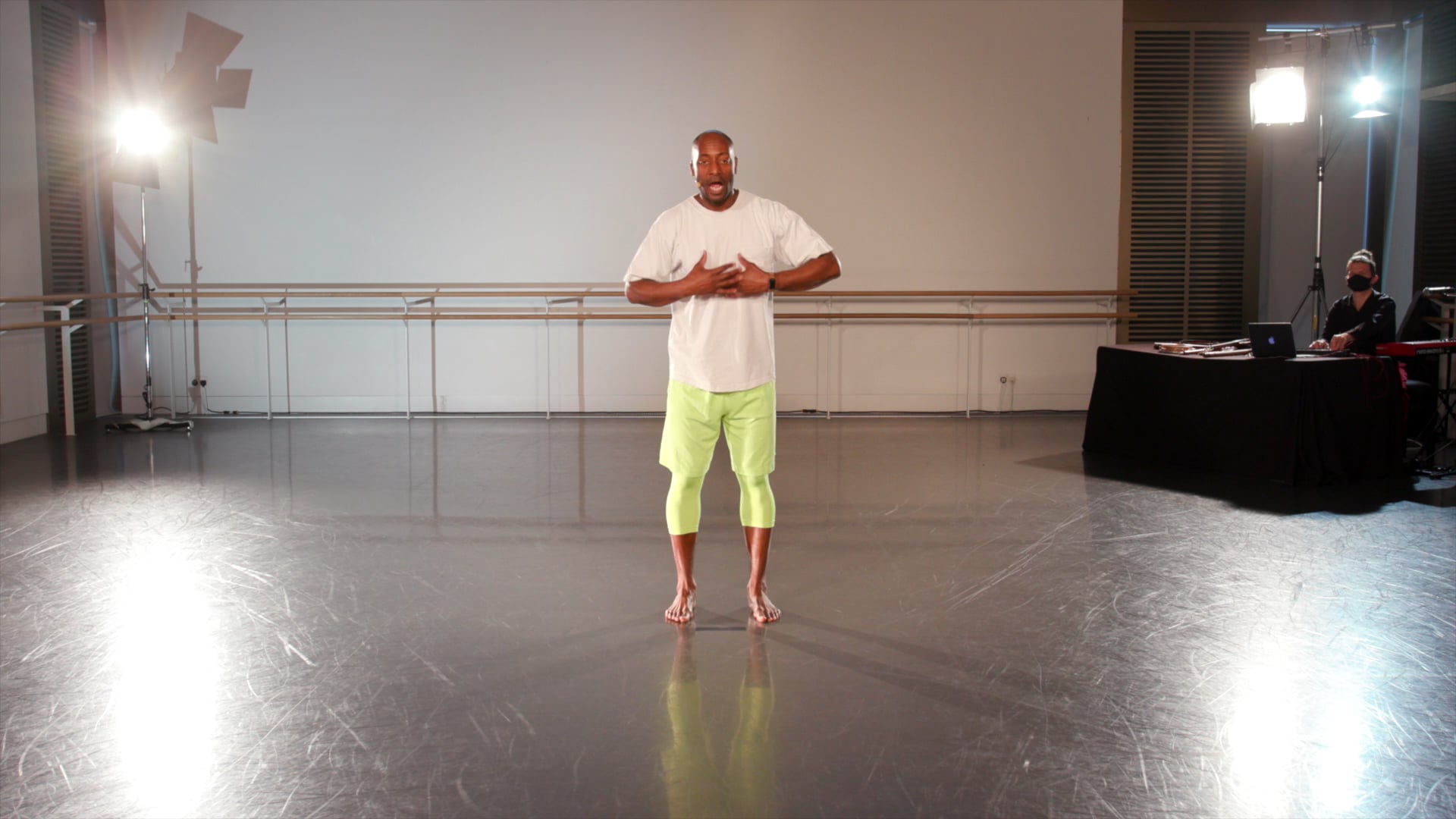 a man standing in a dance studio with his arms crossed.