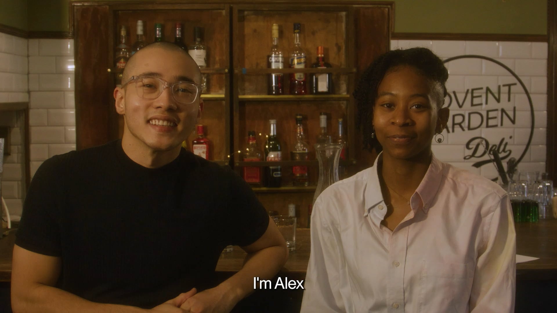 a man and a woman standing in front of a bar.