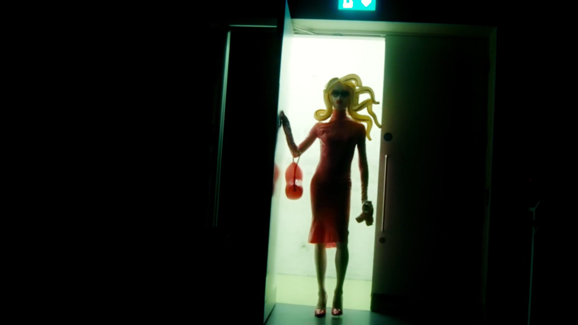 a woman in a red dress standing in a doorway.