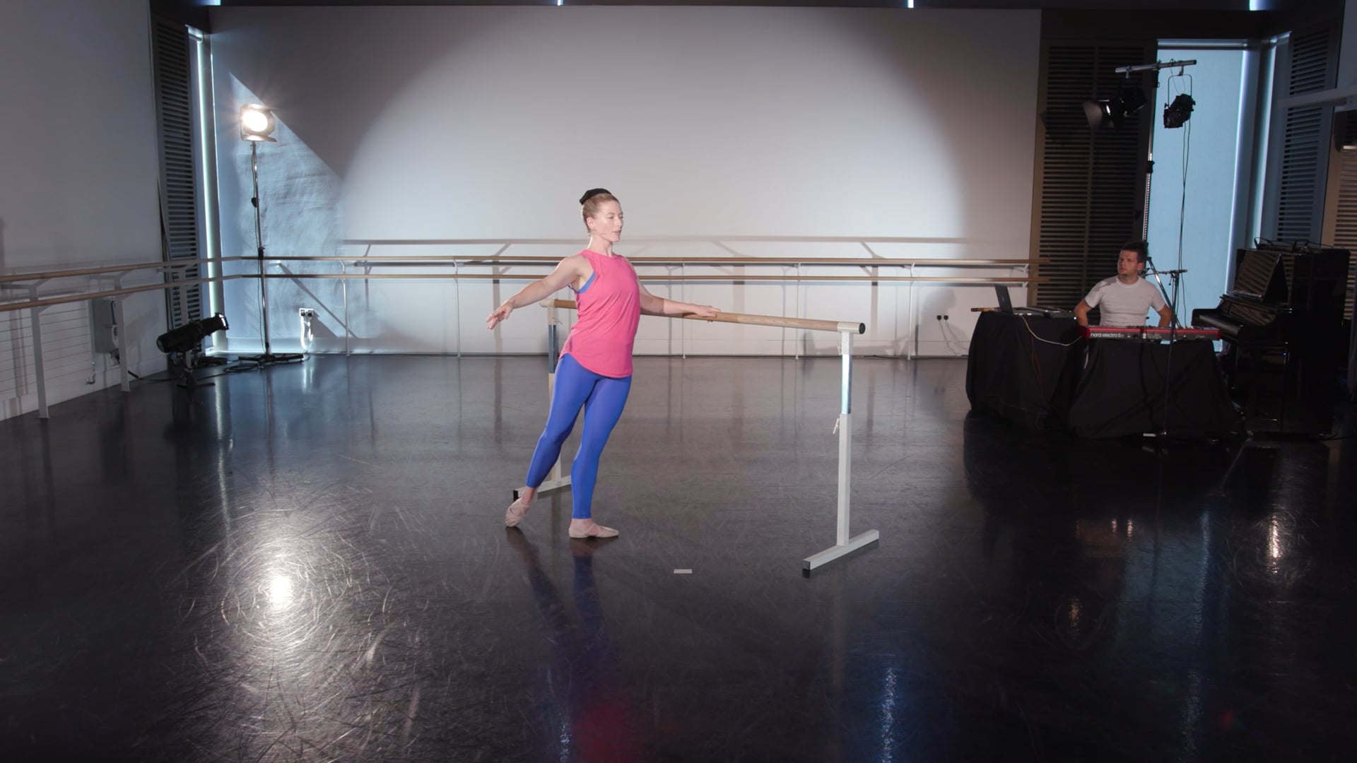a young girl is practicing ballet in a studio.
