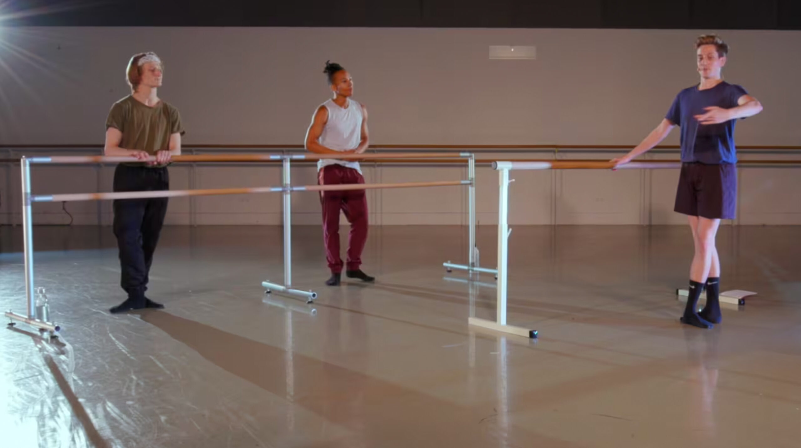 A group of three dancers during an advanced ballet class inside the studio