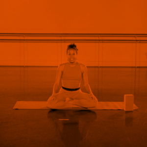 Teacher in a relaxing yoga pose talking on camera to her students