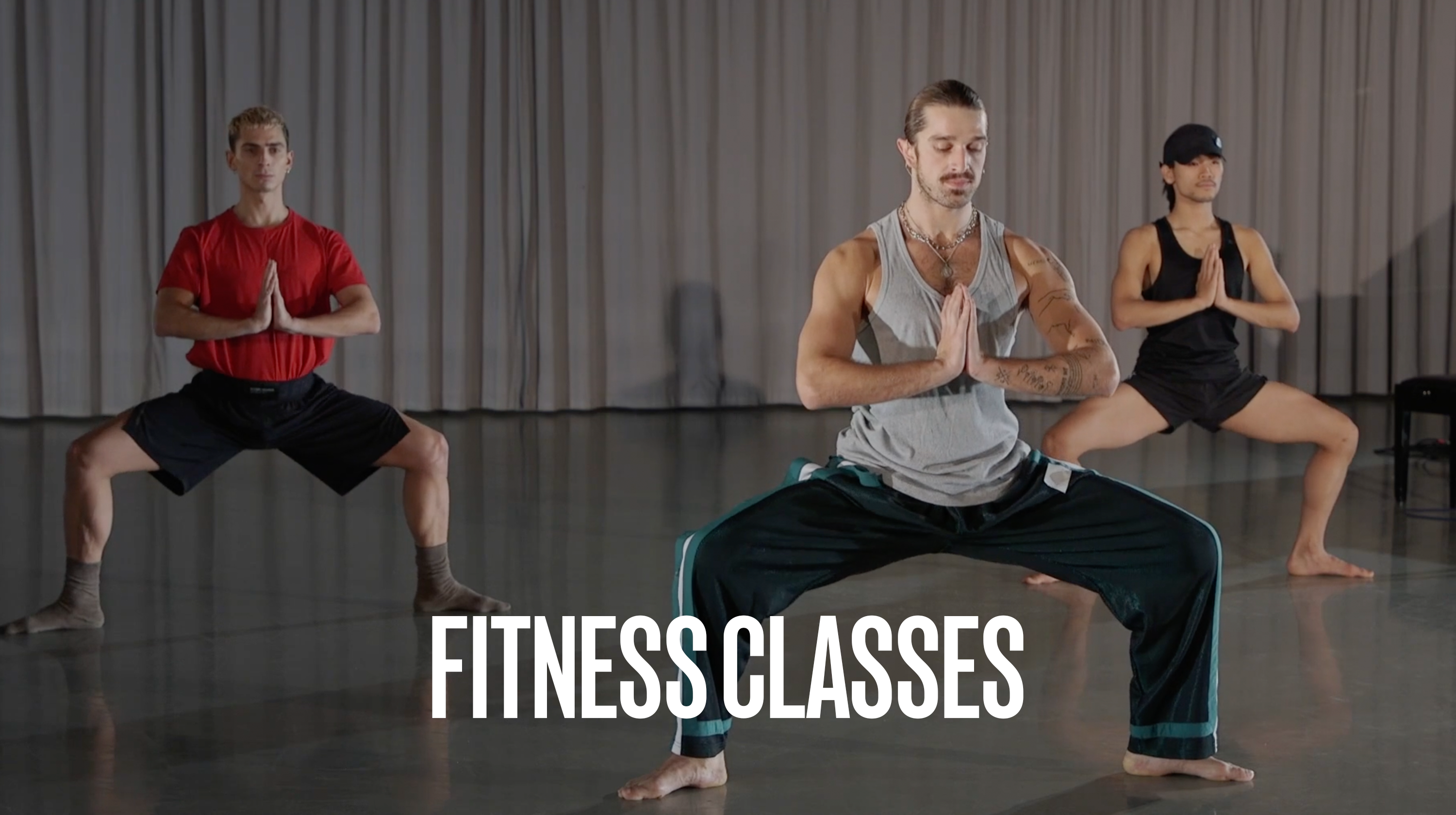 Three dancers in studio with the teacher at the front wearing a grey shirt and blue trousers