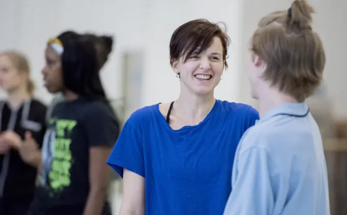 A woman in a blue shirt smiling.