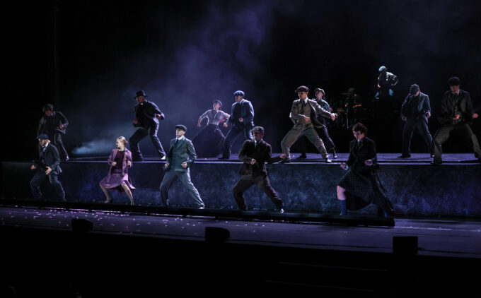 Rambert's Peaky Blinders in performance. dark image with daners daning on stage dressed in Peaky Blinders cast