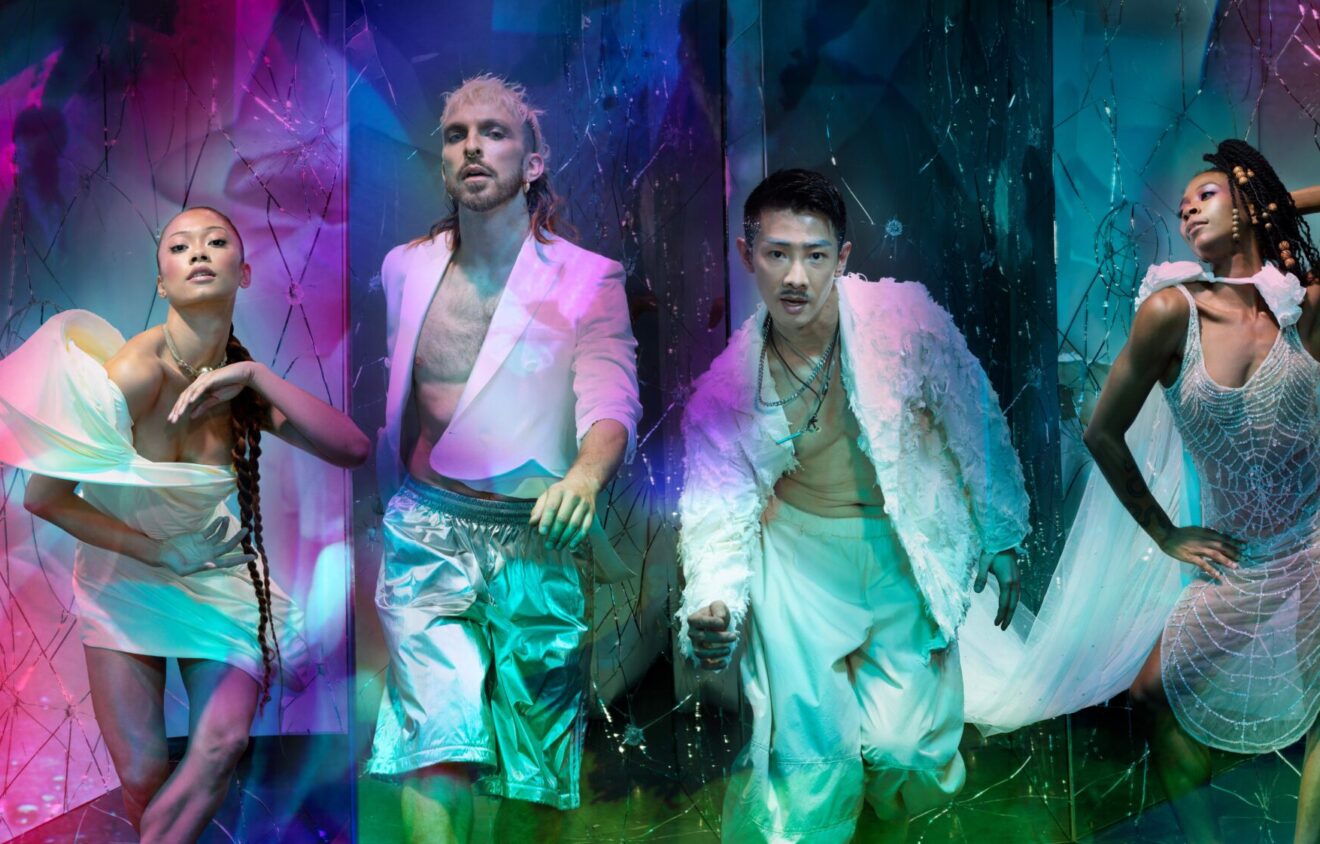 This is Rambert lead image with four dancers dressed in white looking at the camera and overlay colourful projections