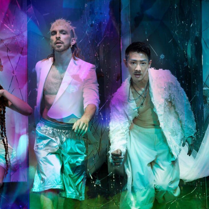 This is Rambert lead image with four dancers dressed in white looking at the camera and overlay colourful projections